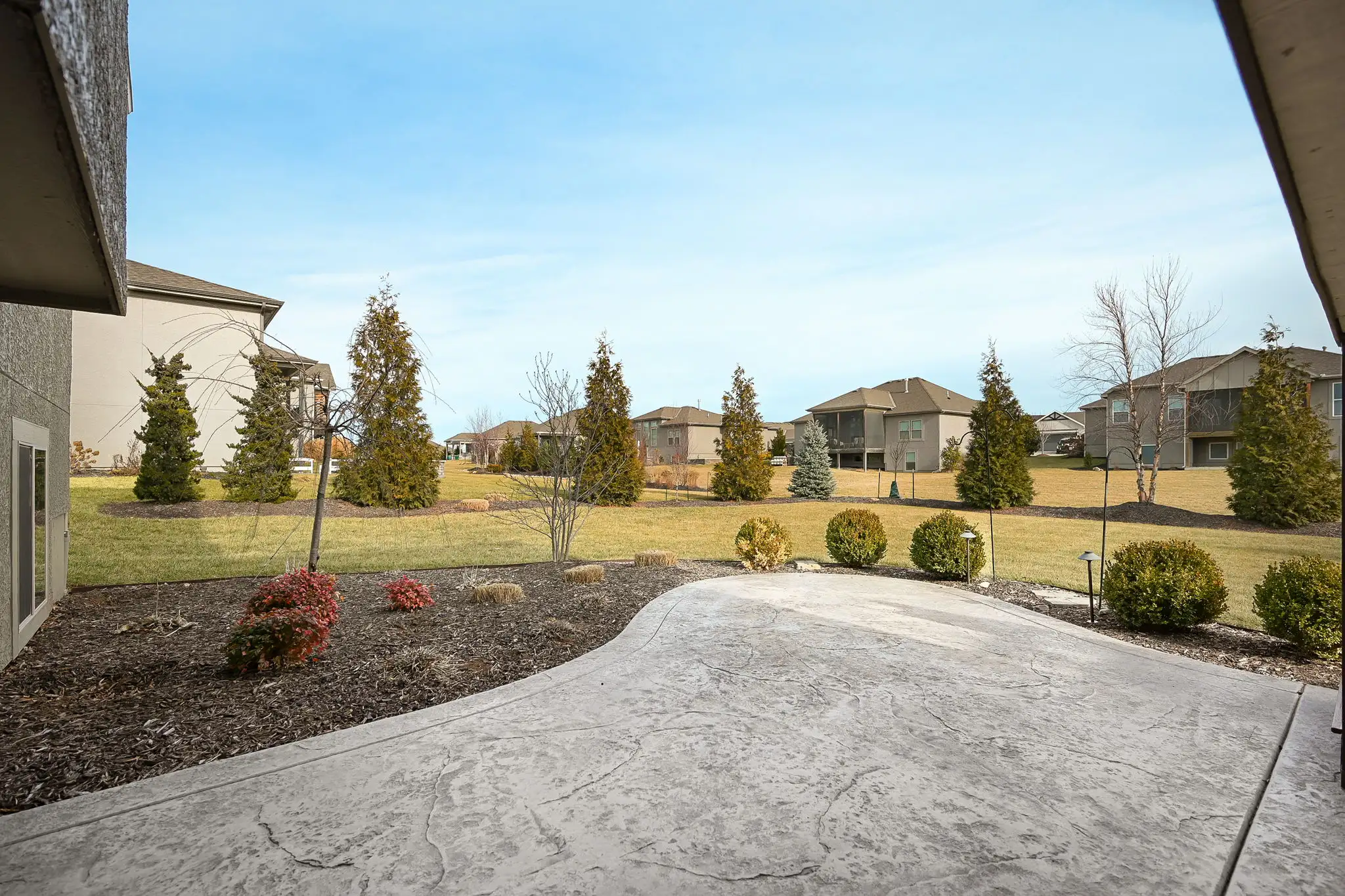 Stamped concrete patio with completed landscaping in Cedar Creek